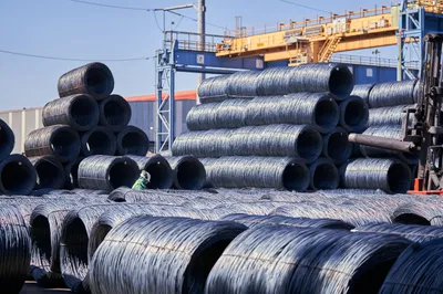 Stacks of steel wire coils stored outdoors at an industrial yard